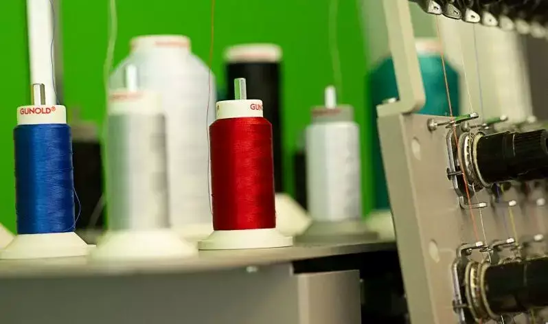 Nahaufnahme von verschiedenen Garnen an einer Stickmaschine.